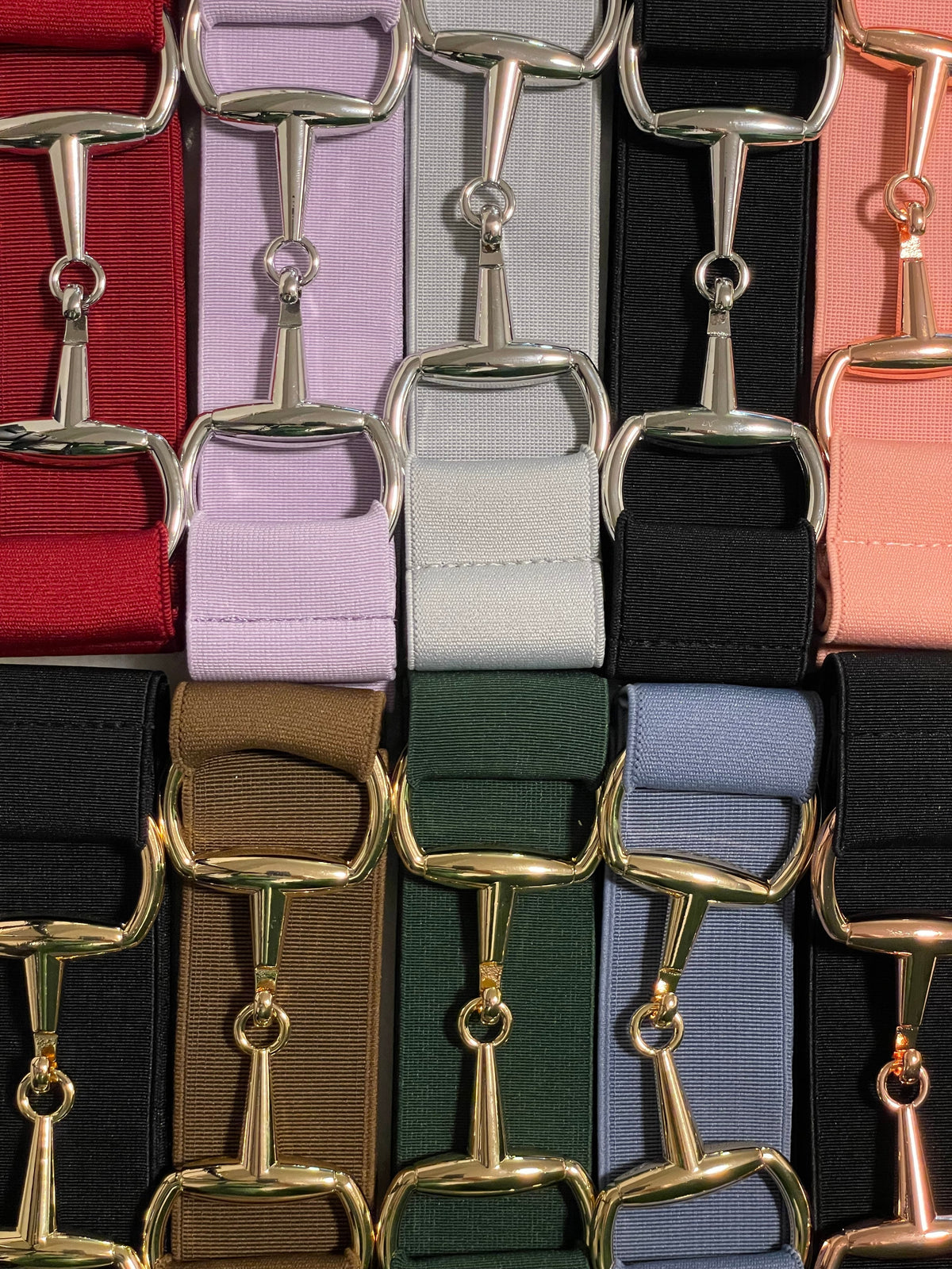 Fire par fargerike ridetøy sokker i blå, lys blå, beige og rosa hengende på en trestolpe.